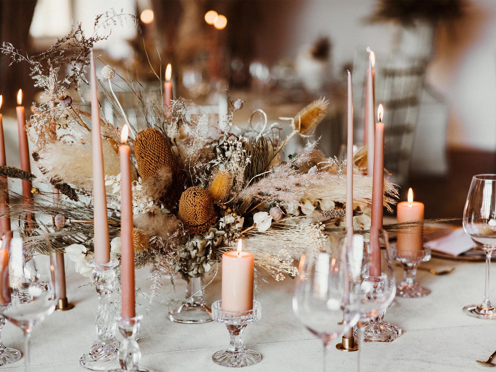 Ozdobny bukiet kwiatów i świece na okrągłym stoliku podczas przyjęcia weselnego w Pałacu Goetz
